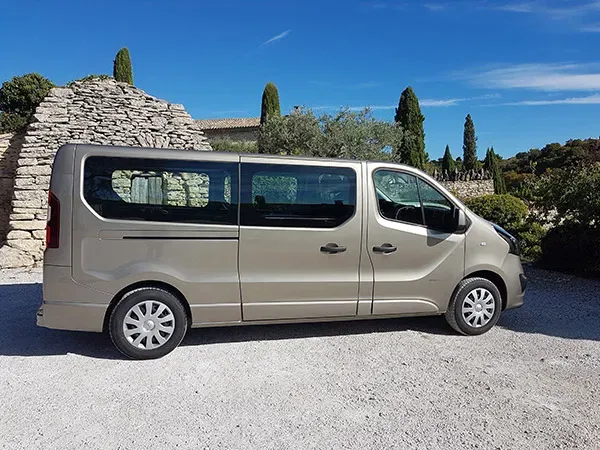Véhicule monospace de transport funéraire de couleur beige garé en extérieur