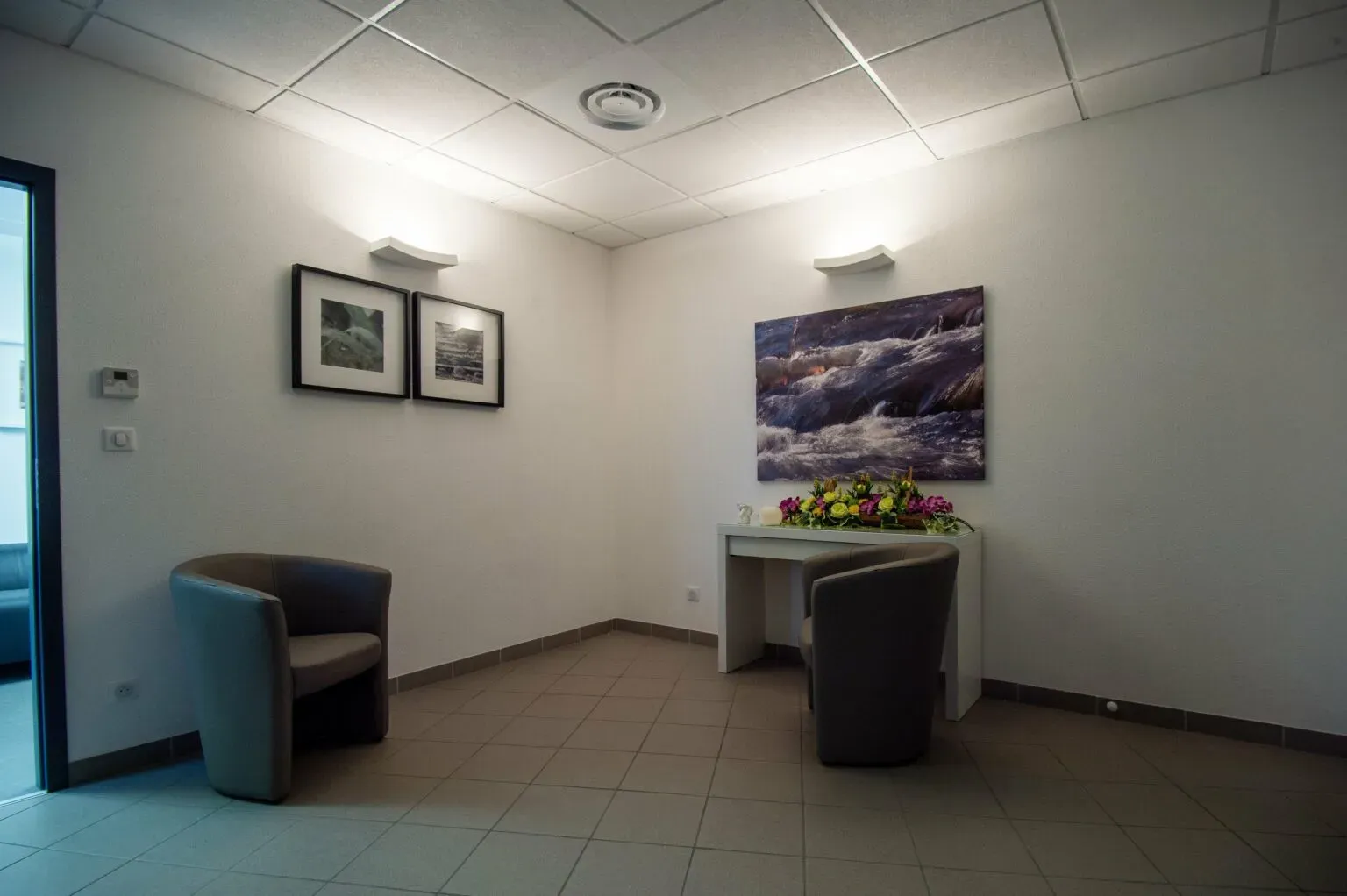 Salon de recueillement intimiste de la chambre funéraire aménagé avec des fauteuils